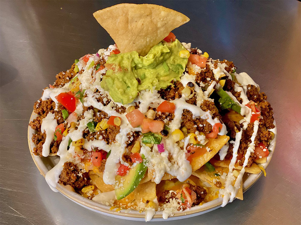 Loaded nachos topped with guacamole, pico de gallo and crema